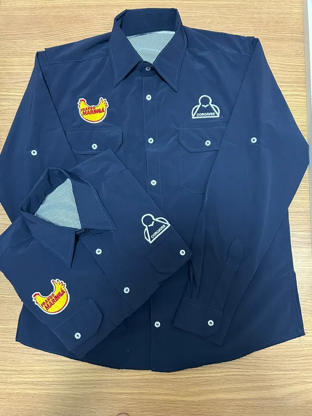 Camisas de Campo azul marinho com dois bordados no peito, um de cada lado.