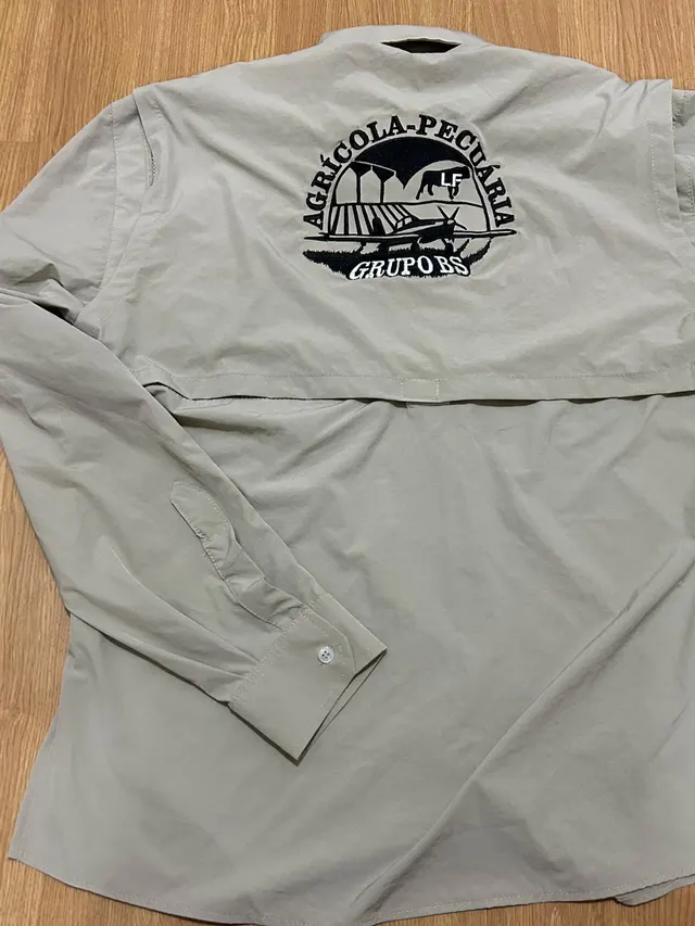 Costas da Camisa de Campo areia, com o bordado grande da marca do cliente sobre a pala.